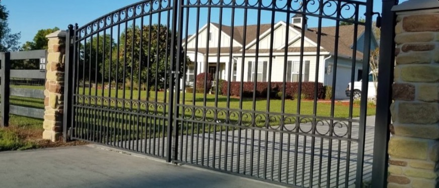 Ornamental steel estate gate with stone columns