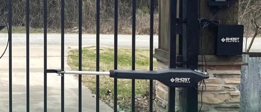 Automatic gate opener arm installed on a drive gate